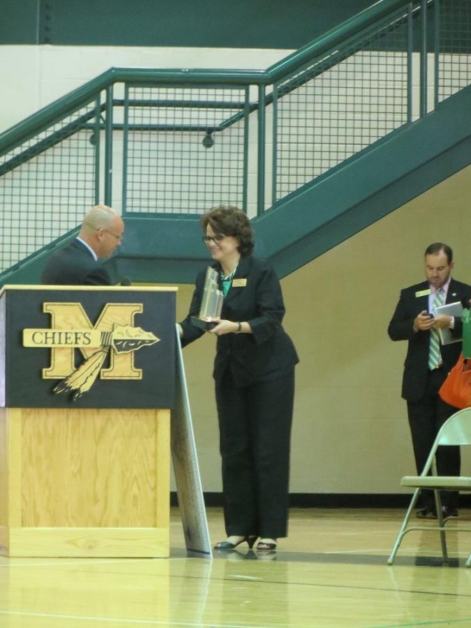 State Superintendent Dr. John Barge presents Ms. Lisa Fine with the star-shaped trophy, a symbol of the students academic excellence.