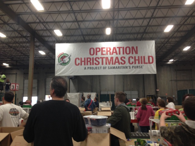 Hundreds+of+volunteers+pause+to+pray+over+the+boxes.+