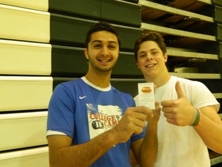 Senior Adam Sheikali poses with friend and fellow senior, Andrew Johnson, for a photo with the free Chick-fil-a sandwich coupon. 