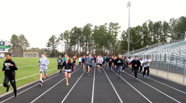 Runners stride to finish dynamic warm-ups. 