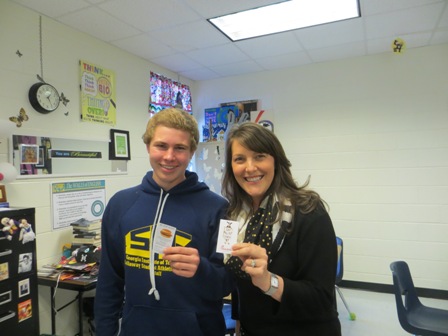 Sophomore Owen Miller and his English teacher, Maggie Walls, pose for picture together with their free Chick-fil-a sandwich coupons.