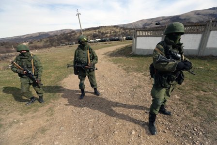 Russian soldiers stand guard blocking a Ukranian military base