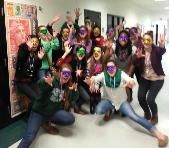 Multicultural club members pose in their Mardi Gras day masks and beads. 