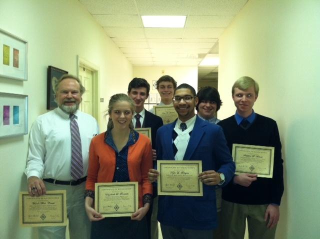Debate team poses with certificates.