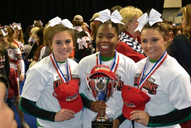 Catie was a part of the state championship team during the 2013 season for MHS Varsity Cheer Team. She is pictured with captains Mary Sousley and Shannon Hinds. 