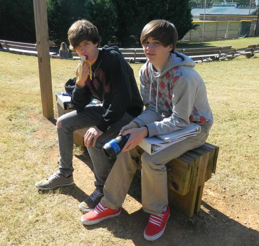 Sophomore Clayton Bryant and Junior Trent Dehart take advantage of warm weather by sitting outside. 