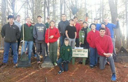 The scouts of troop 175 gather around the sign at the Planterra Civil War cemetery after they finished removing overgrown roots, cutting weeds and removing leaves. 