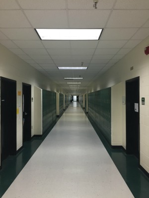 This hallway looks almost endless because of the green color and  white walls.