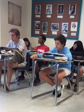 Students observe and take notes on a semifinal debate in the winners bracket of the double elimination tournament