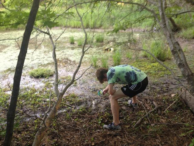 A student picks up trash near Lake Peachtree.