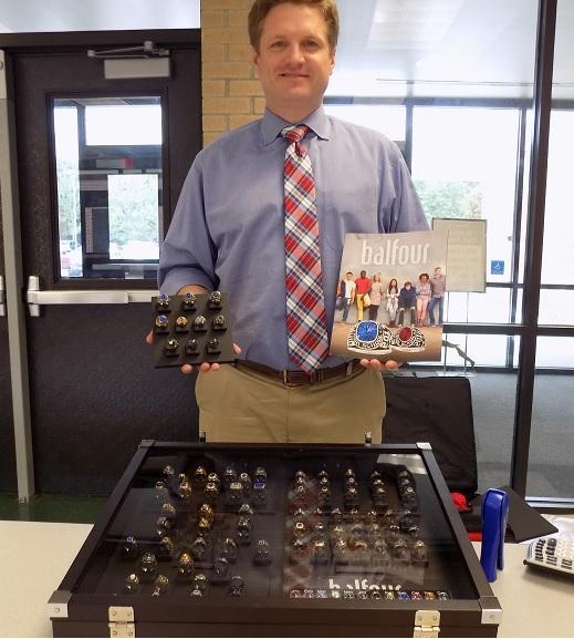 Sean Smith, a representative of Balfour, shows students various designs.