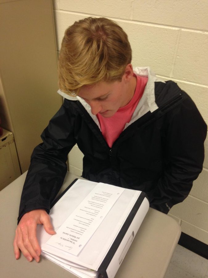 Senior Jeff Balco studies his poem before he presents in Mr. Lector Zamore's Spanish IV class.