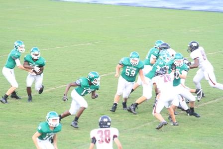 Freshman Kyle Riesselman handing the ball off to sophomore, Ahmad Ragland with Sophomore Jake Ellis the lead blocker.