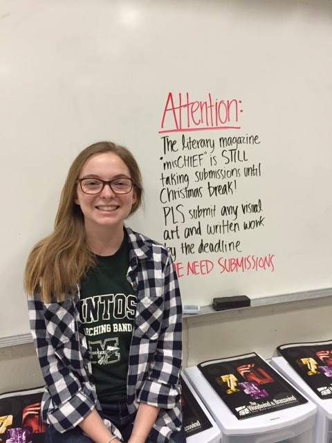 Senior staff member Grace Davis asks students to submit their works.