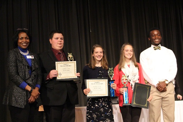 Junior Kyle Ewers presents science fair winners with their awards.