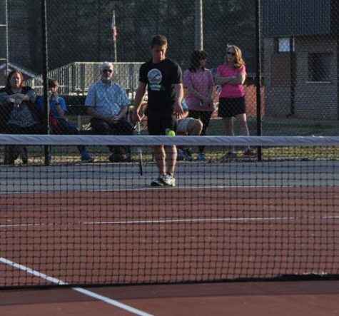 Sophomore Will Pickard bounces the tennis ball before hitting a serve in his singles match against Northgate.