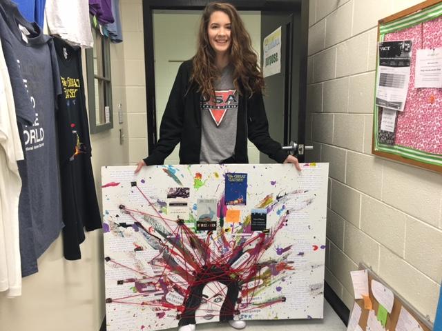Junior Shelby Doyal holds her mind map poster she created for the end of the year project. Shelbyl used painting and red string to demonstrate her ideas.  