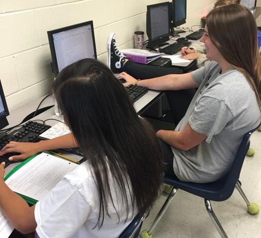 Juniors Caroline Chang and Brianna Dannehl type up the songs for their psychology projects.