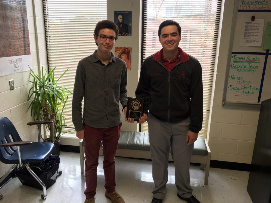 Debaters Jackson Fuentes and Samuel Ellis pose win a quarter-finalist plaque.