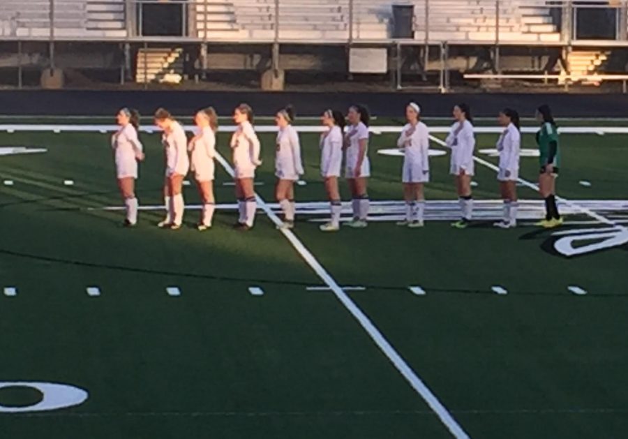 The McIntosh team stands for the National Anthem as the players prepare for the start of this rivalry game.