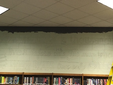 The quote that they are painting on the library wall says, A reader lives a thousand lives before he dies. The man who never reads lives only one.