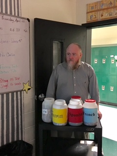 German teacher Mr. Kevin Keough pushes around the penny war cart during first period.