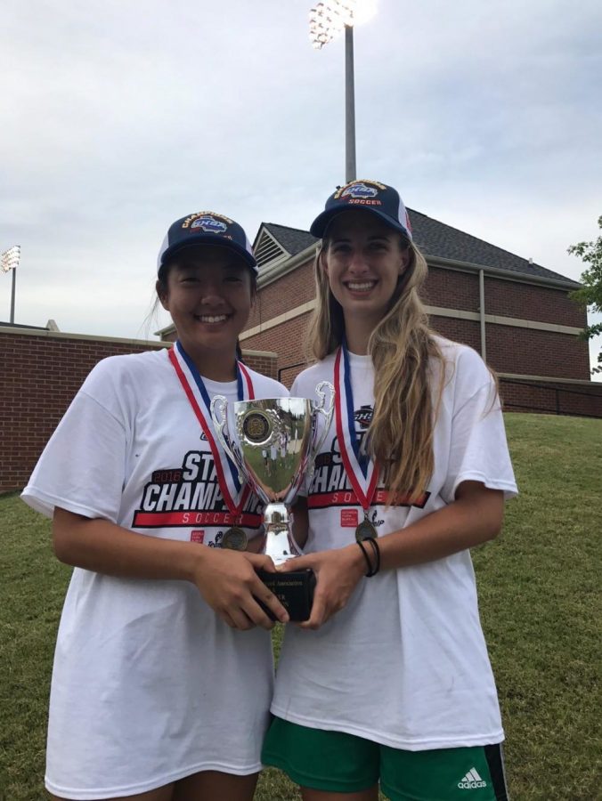 Sophomore Stephanie Yi and senior Taylor Malasek hold up the team winning trophy at Mercer University. 