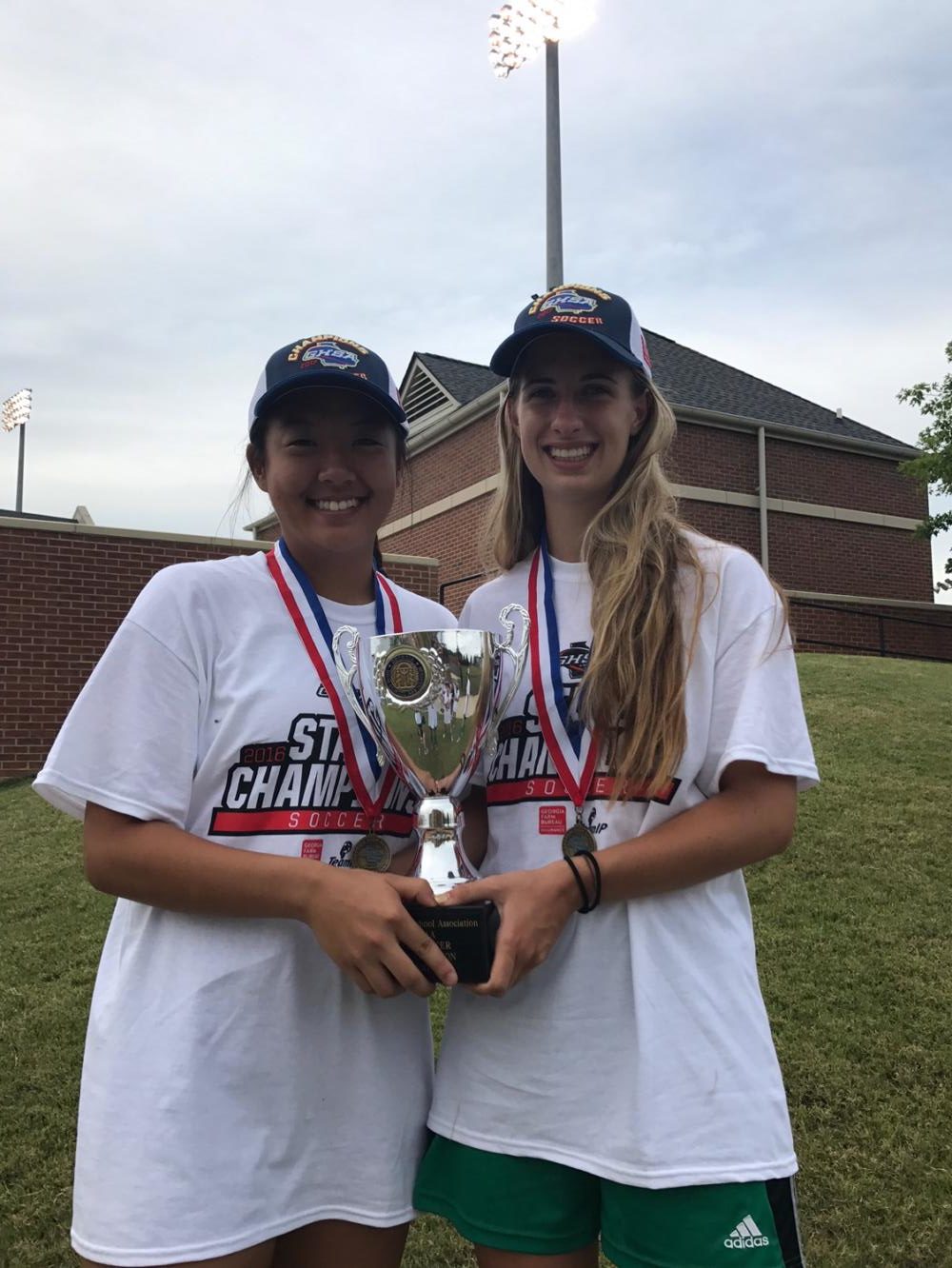 Sophomore Stephanie Yi and senior Taylor Malasek hold up the team winning trophy at Mercer University.