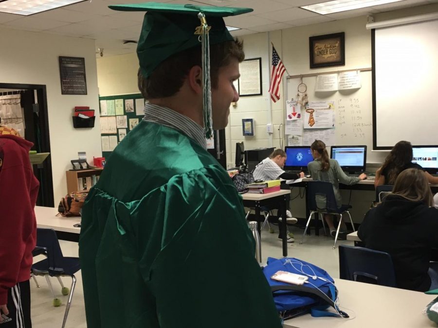 Senior+Connor+Whittle+tries+on+his+newly+acquired+cap+and+gown+at+school+on+Friday.