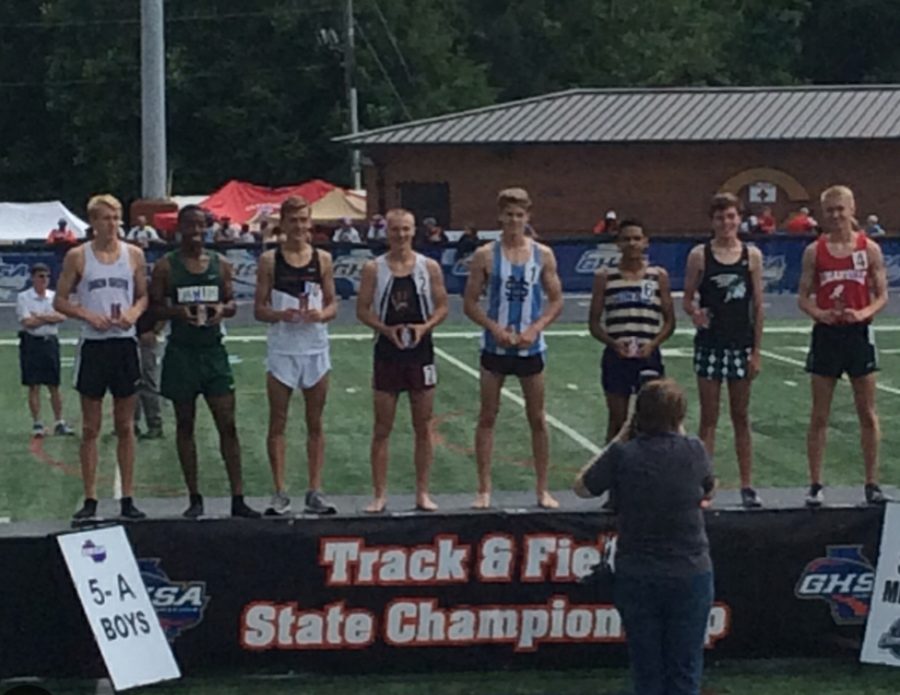 Winners stand on podium to receive medals  for the boys 3200 meter race at the State Championship.