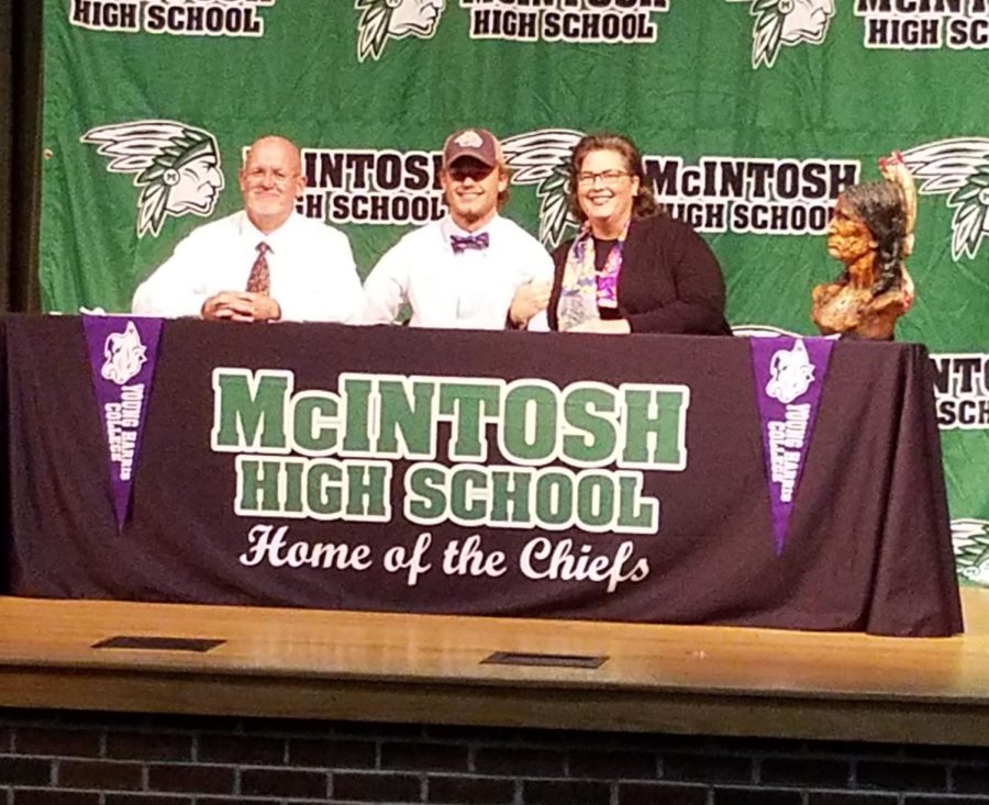 Senior Huck McCollum with his parents in the auditorium on signing day, on Thursday, November 15. 