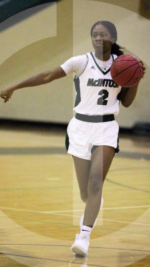 Kennedi Miller dribbling up the court directing her teammates where to go for the play. 