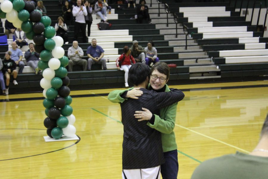 Senior manager Nelson White hugs mother after being recognized for four years of assisting the basketball program.