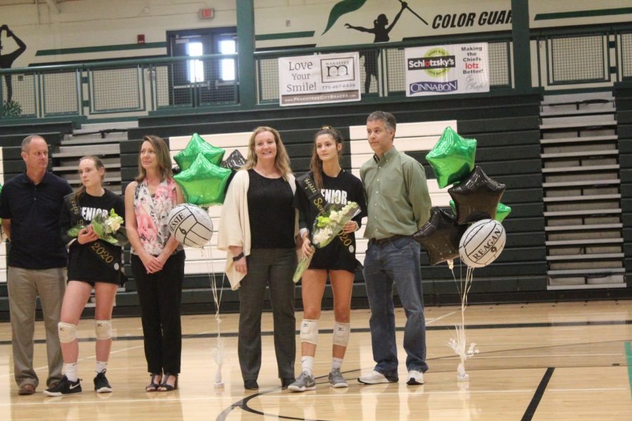 Senior posing for photos with family