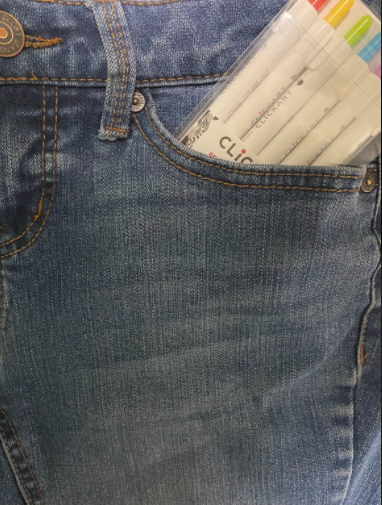 Image taken by Savannah Hayes. Pair of woman jean pockets, with school stationary hanging out of the left pocket.