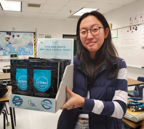 Junior Olivia Shim, a member of the Drug Free Fayette Youth Action Team, pictured with a display of the deactivation pouches. Photo courtesy of Wendy Mabon
