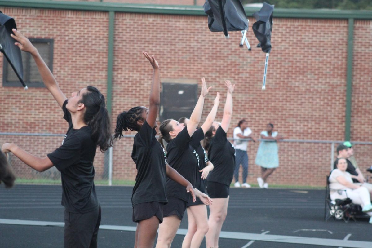Colorguard members warm up on the turf before performing their halftime show for the stands.