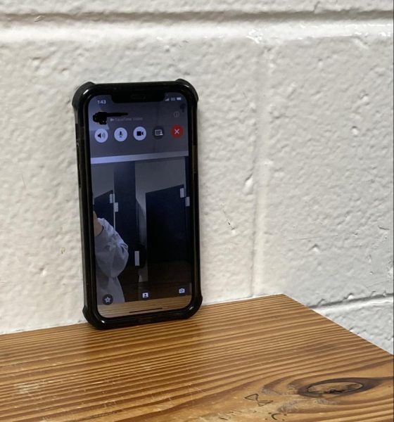 Photo illustration of a phone propped on the shelf of the girls bathroom.