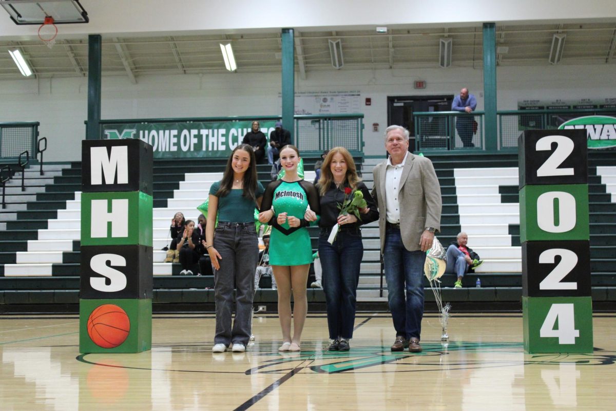 Chiefette Olivia Anderson walks the court escorted by her parents and sister. 