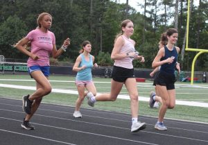 Girls Cross Country running the track during a September practice. Photo by Mikayla Santiago