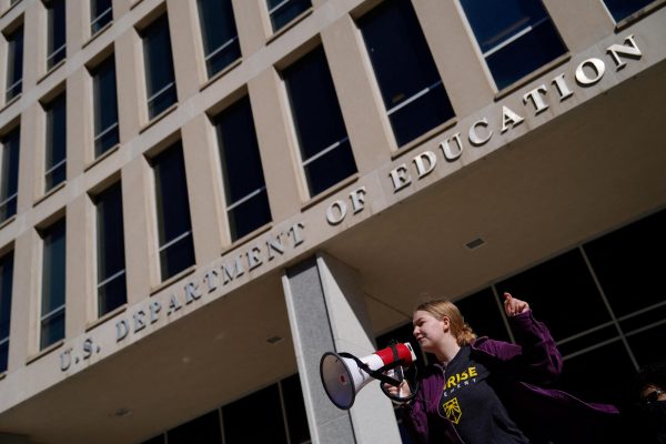 A demonstrator attends a Defend Our Schools rally to protest U.S. President Donald Trump's executive order to shut down the U.S.Department of Education outside its building in Washington, D.C., U.S., March 21, 2025. REUTERS/Kent Nishimura