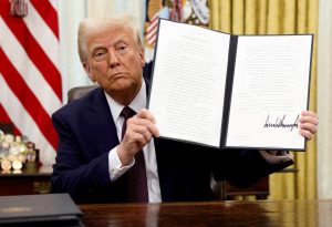 U.S. President Donald Trump holds a signed executive order on cryptocurrencies, in the Oval Office of the White House, in Washington, U.S., January 23, 2025.   REUTERS/Kevin Lamarque