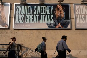 People walk past an American Eagle ad campaign featuring Sydney Sweeney in New York City, U.S., August 4, 2025. REUTERS/David 'Dee' Delgado