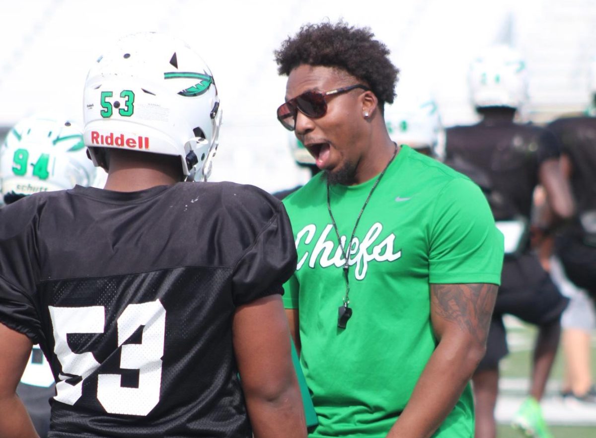 Coach Iyante Price motivates a player on the field during a September afternoon practice. 