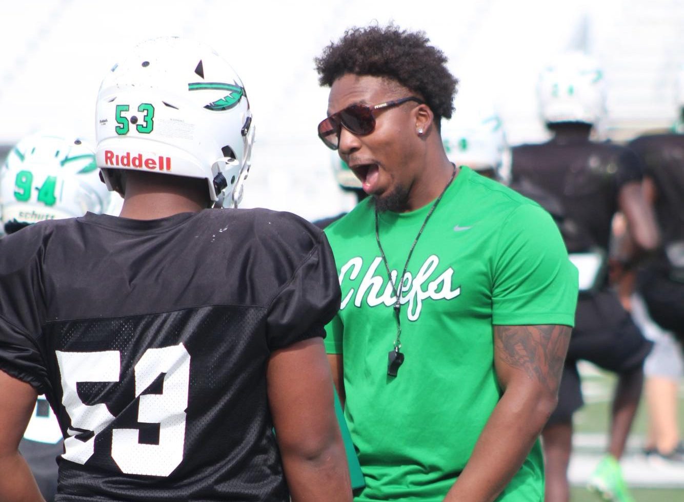 Coach Iyante Price motivates a player on the field during a September afternoon practice. 