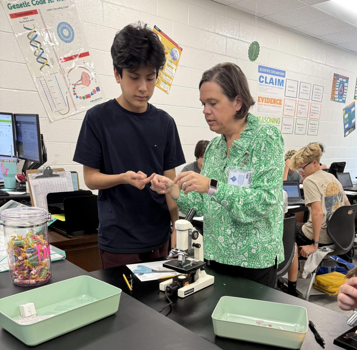 Butera helping explain how to use a microscope in her biology lab.