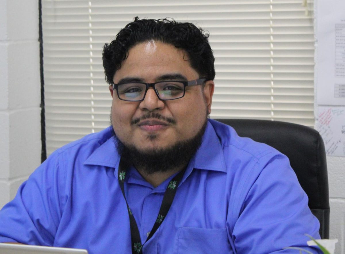  Jonathan Rivera, New English Teacher, sitting at his desk in his classroom.