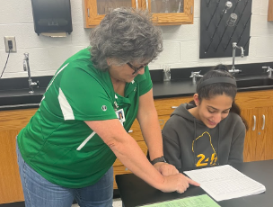 A now returning teacher, Stacey Smith, teaching Zahar Jimali chemistry