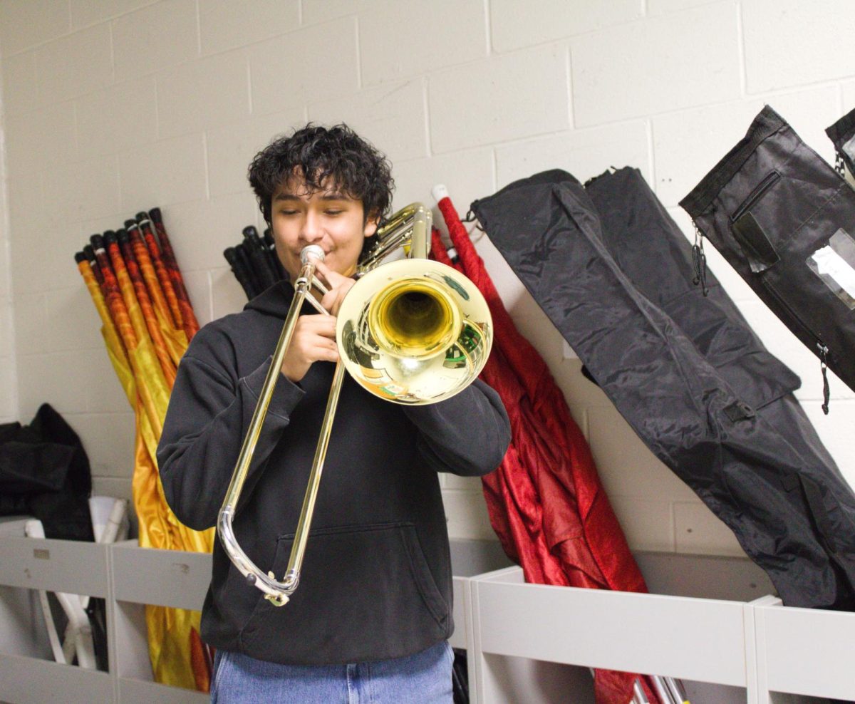 Photo of Leo Gil warming up in the colorguard closet in the band room.