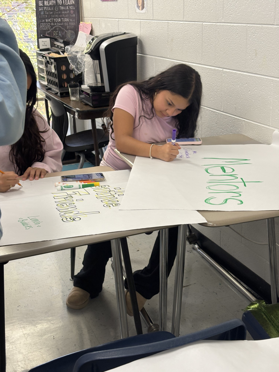 Freshman Destiny Perez at a Sources of Strength meeting writing their strengths under different categories